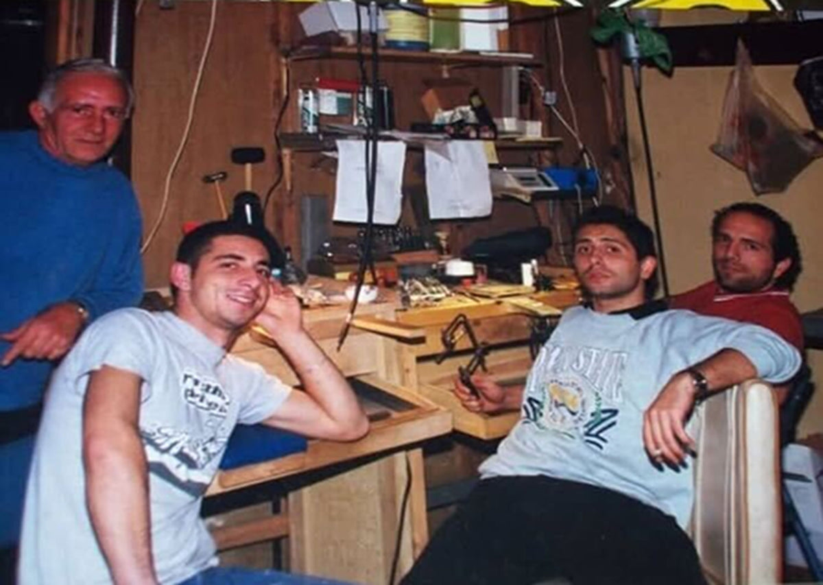 Four men are sitting together in a jewelry workshop 