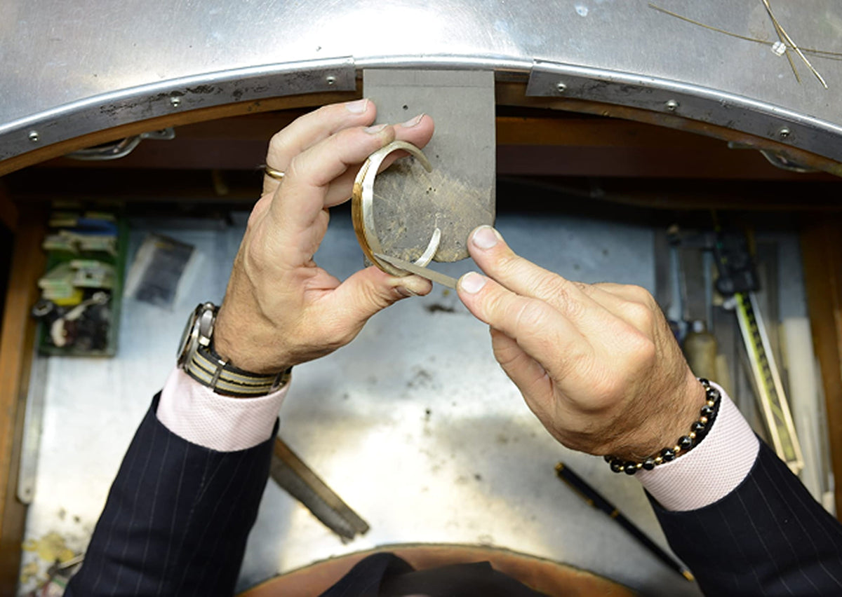 Person working on crafting a piece of gold.